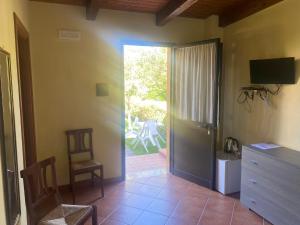- un salon avec une porte s'ouvrant sur une terrasse dans l'établissement B&B La Torretta, à Gasponi