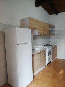 a kitchen with a white refrigerator and wooden cabinets at CAMPING MADDALENA in Palinuro