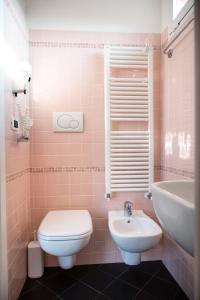 Baño de color rosa con aseo y lavamanos en Hotel Selene - Vista Mare, en Riccione