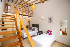 a room with two beds and a staircase in it at Pousada Morada Do Sol in Arraial d'Ajuda