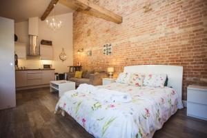 a bedroom with a bed and a brick wall at Lynford Holiday Cottages nestled in the heart of Thetford Forest in Mundford