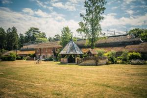 a building with a gazebo in a yard at Lynford Holiday Cottages nestled in the heart of Thetford Forest in Mundford