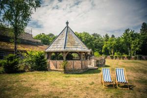 two chairs and a gazebo in a yard at Lynford Holiday Cottages nestled in the heart of Thetford Forest in Mundford