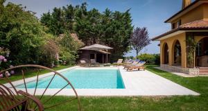una piscina en un patio con sillas y una casa en Villa Enara, en Hendaya