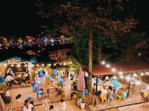 uma multidão de pessoas sentadas às mesas à noite em Gió bungalow em Sa Pa