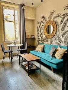 a living room with a blue couch and a table at Le charmant quai bourgeois in Bordeaux