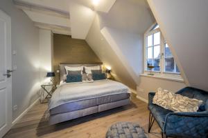 um quarto no sótão com uma cama e uma cadeira em Haus Sylter Momente em Westerland