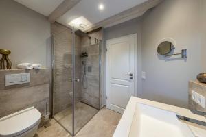 uma casa de banho com um chuveiro, um WC e um lavatório. em Haus Sylter Momente em Westerland
