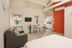 Habitación con cama y sala de estar con puerta roja. en Vicolo Zini Apartments, en Verona