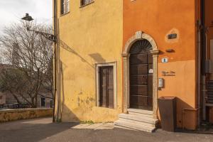 ヴェローナにあるVicolo Zini Apartmentsの窓とドアのあるオレンジ色の建物