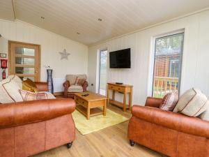 a living room with two couches and a tv at Robin Lodge in Skipton