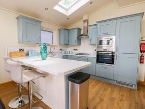 a kitchen with blue cabinets and a white counter top at Robin Lodge in Skipton