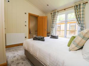 a bedroom with a large bed and a window at Robin Lodge in Skipton