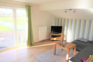 a living room with a couch and a tv at Kleinheide 2 in Berumbur