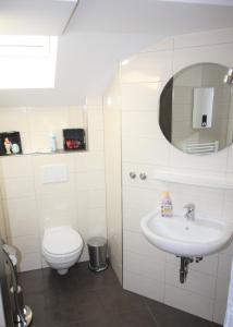 a white bathroom with a toilet and a sink at Kleinheide 2 in Berumbur