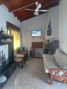 - un salon avec un canapé et un ventilateur de plafond dans l'établissement Casa en la Colonia - PetFriendly, à Concepción del Uruguay
