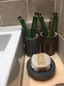 two cups with toothbrushes and a box on a counter at La Pastora Apartamento con parking in Gavà