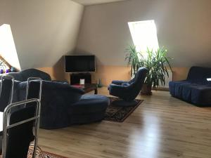 a living room with two blue couches and a tv at Citellus Apartman in Dunasziget