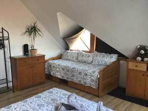 a attic bedroom with a bed and a window at Citellus Apartman in Dunasziget