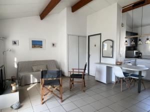 cocina y sala de estar con mesa y sillas en 52amareyeurs, en Le Château-dʼOléron