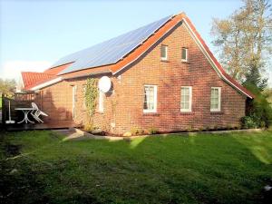 a brick house with solar panels on the roof at Kleinheide 1 in Berumbur