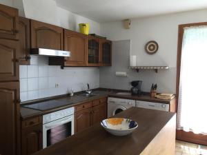 una cocina con armarios de madera y un bol sobre una mesa en Sejour relaxant a Grand-Village, en Grand-Village-Plage