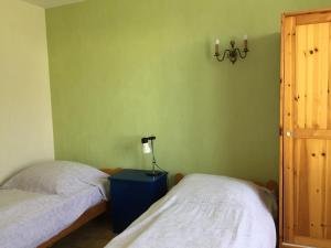 Un dormitorio con dos camas y una lámpara sobre una mesa. en Sejour relaxant a Grand-Village, en Grand-Village-Plage