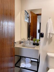 a bathroom with a sink and a toilet at LOFT BC in Balneário Camboriú