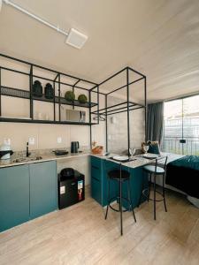 uma cozinha com armários azuis e uma cama num quarto em LOFT BC em Balneário Camboriú