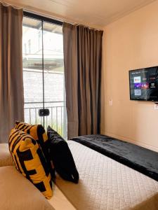 um quarto com uma cama e uma televisão na parede em LOFT BC em Balneário Camboriú