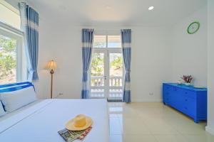 1 dormitorio con 1 cama con sombrero en Casa Villa - Floral Park- Sealinks City Resort, en Phan Thiet