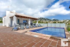 een villa met een zwembad en een huis bij Villa Marigold - Grupo Turis in Benissa