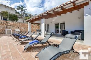 een rij stoelen op de patio van een huis bij Villa Marigold - Grupo Turis in Benissa