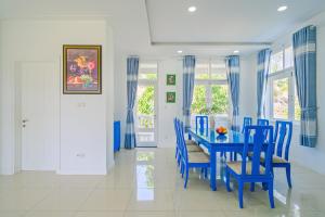 a dining room with a blue table and chairs at Casa Villa - Floral Park- Sealinks City Resort in Phan Thiet