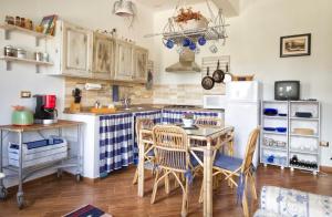 アルゲーロにあるAppartamento Arlinaのキッチン(テーブル、椅子、冷蔵庫付)