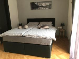 due gatti sdraiati su un letto in una camera da letto di Appartement Kuhglocken Ferienhaus Fuenf Sinne a Döbriach