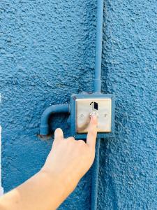 a person is unlocking a blue wall with a socket at Maktub Costanera - Hostal Boutique in Santiago