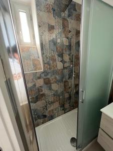 La salle de bains est pourvue d'une douche avec une porte en verre. dans l'établissement B&B VILLA LA GINESTRA - camere, à Boscoreale