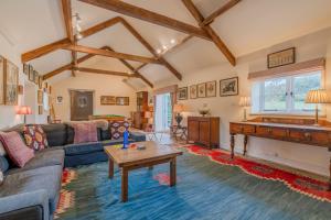 a living room with a couch and a piano at Lodge Barn in Lydney