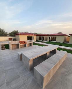 a patio with two benches on top of it at UptownRak FarmHouse in Diqdāqah