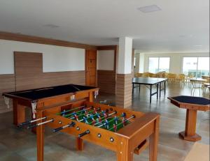 a pool table in a room with tables and chairs at Apto Le Bon Vivant Vista Mar in Arraial do Cabo