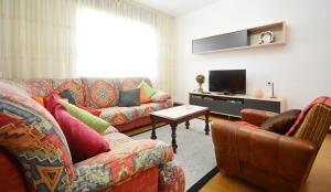 a living room with two couches and a tv at Casa con jardín en Vilanova de Arousa in Pontevedra