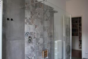 una doccia con una porta in vetro in un bagno di B&B I due tigli a Travedona