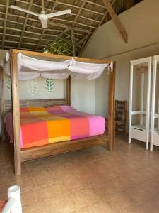 1 dormitorio con cama de madera y dosel en Villa Punta Coral, en Las Galeras