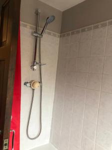a bathroom with a shower with a shower head at The Brougham House in Bath