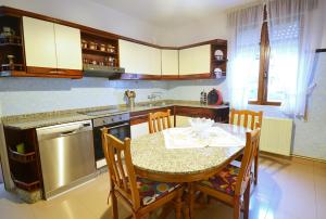 a kitchen with a table and a table and chairs at Casa con jardín en Vilanova de Arousa in Pontevedra
