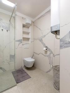 een badkamer met een toilet en een glazen douche bij Residence Nar in Poreč