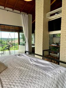 a bedroom with a large white bed in a house at Chalé Village Jângal in Machado