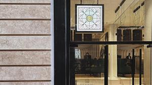 a window of a building with a clock on the wall at The Embassy Valletta Hotel in Valletta