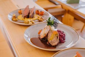 two plates of food on a table with food at Hotel Dreiländerblick Dornbirn in Dornbirn